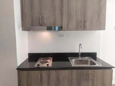 a kitchen with a sink and a stove at FAME Bedroom in Manila