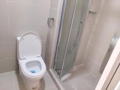 a bathroom with a toilet and a shower at FAME Bedroom in Manila