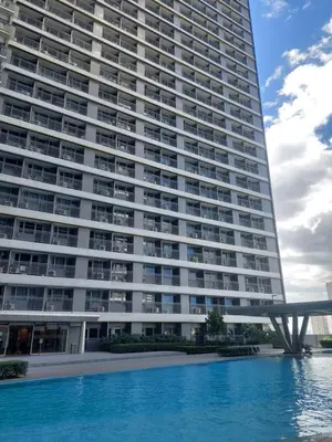 a large building with a swimming pool in front of it at FAME Bedroom in Manila