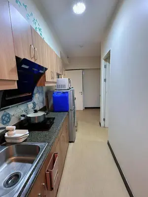 a kitchen with a sink and a refrigerator at Torre De Manila in Manila