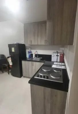 a small kitchen with a stove and a refrigerator at S Residences Two Beds Room Near MOA Pasay Manila in Manila