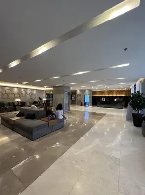 a person sitting on a couch in a lobby at S Residences Two Beds Room Near MOA Pasay Manila in Manila