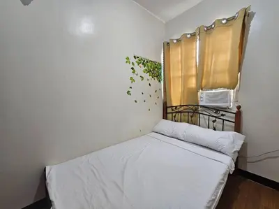 a small bedroom with a bed and a window at Alohas House in Cupang