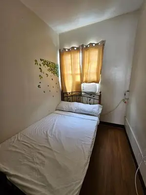 a small bedroom with a bed and a window at Alohas House in Cupang
