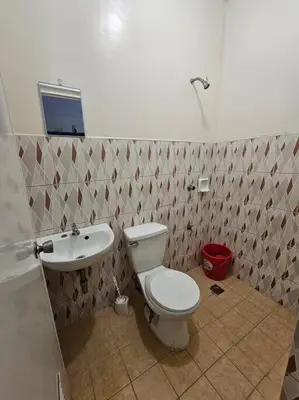 a bathroom with a toilet and a sink at Alohas House in Cupang