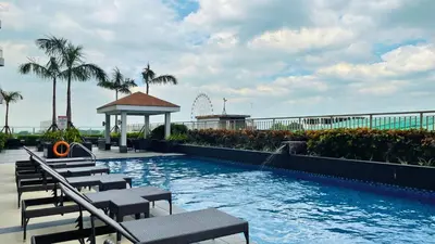 a swimming pool with chairs and a roller coaster at SMDC Coast Residences in Manila