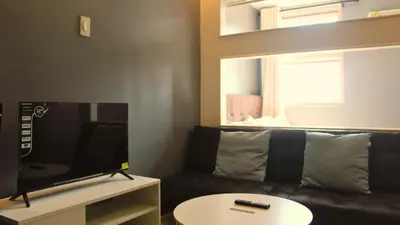 a living room with a couch and a tv at SMDC Coast Residences in Manila