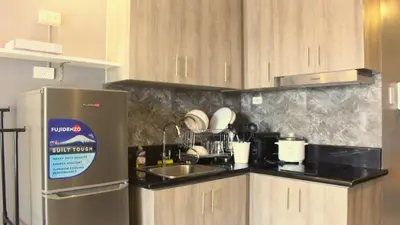 a kitchen with a stainless steel refrigerator and a sink at SMDC Coast Residences in Manila