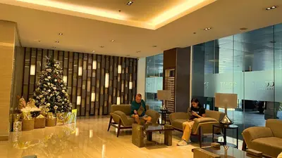 two women sitting in chairs in a lobby with a christmas tree at SMDC Coast Residences in Manila