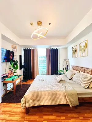 a bedroom with a large bed and a desk at Mhax's Place - Azure Parañaque in Manila