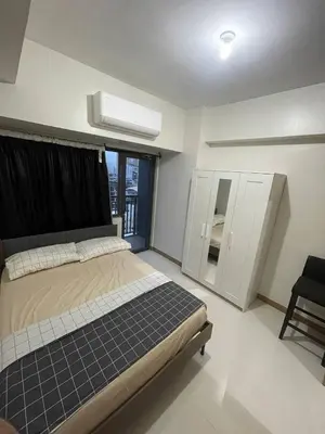 a bedroom with a bed and a window at Red Residences Chino Roces Makati in Manila