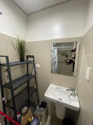 a person taking a picture of a bathroom with a sink at Red Residences Chino Roces Makati in Manila