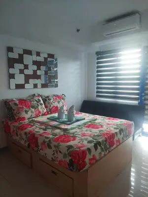 a bedroom with a bed with a table on it at 2BR SEA RESIDENCES By ELSIE D in Manila