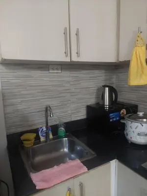a kitchen counter with a sink and a microwave at 2BR SEA RESIDENCES By ELSIE D in Manila