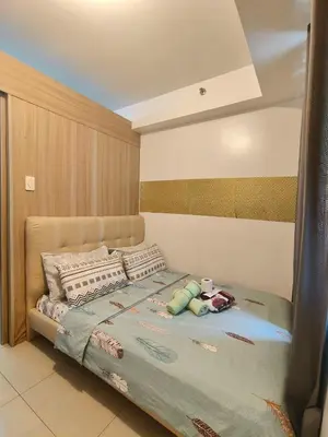 a bedroom with a large bed with pillows at Pasay Shore Residences Staycation in Manila