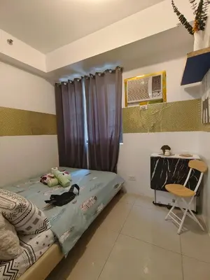 a bedroom with a bed and a desk in it at Pasay Shore Residences Staycation in Manila