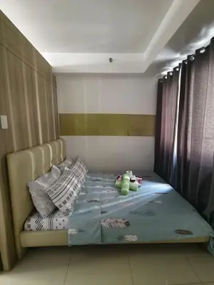 a bedroom with a bed with pillows on it at Pasay Shore Residences Staycation in Manila