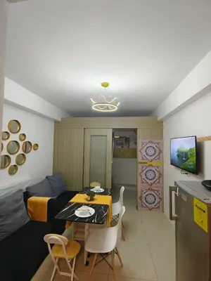 a living room with a table and a dining room at Pasay Shore Residences Staycation in Manila