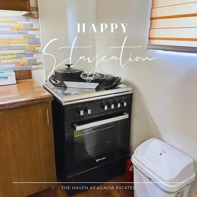a kitchen with a stove and a sign that says happy supernatural at The Haven at Acacia Estates in Manila