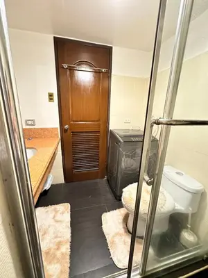 a bathroom with a toilet and a wooden door at The Haven at Acacia Estates in Manila