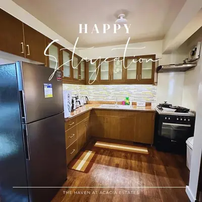 a kitchen with a happy kitchen sign on the wall at The Haven at Acacia Estates in Manila