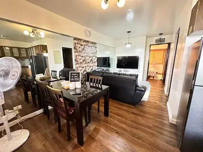 a kitchen and living room with a table and chairs at The Haven at Acacia Estates in Manila