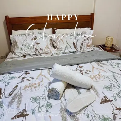 a bed with towels and a happy sign on it at The Haven at Acacia Estates in Manila