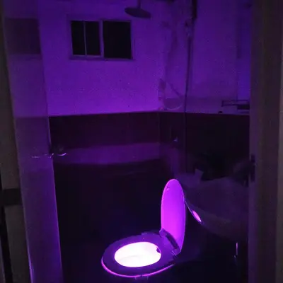 a bathroom with a pink toilet in a purple room at Mench Staycation in Manila