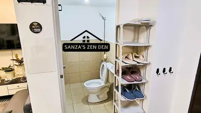 a bathroom with a toilet and a rack with shoes at Modern 2BR Condo with Terrace,Netflix,Pool,& WiFi in Imus