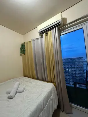 a bedroom with a bed and a window with a view at SD 2 staycation in Manila