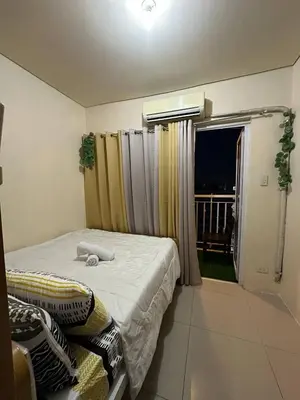 a bedroom with a bed and a window with a balcony at SD 2 staycation in Manila