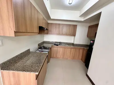a kitchen with wooden cabinets and a counter top at blue sky viewing in Manila