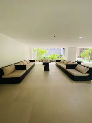 a living room with couches and tables in a building at 1 Bedroom with Balcony near Mall of Asia in Manila
