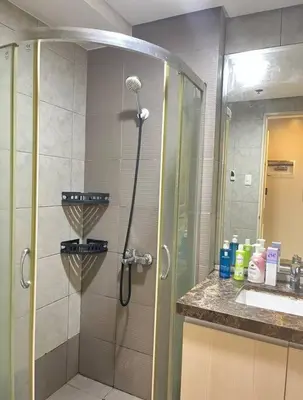 a bathroom with a shower with a glass door at Cozy 1-BR Retreat Near MOA Pool view in Manila