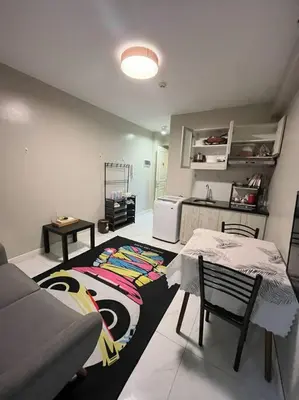 a living room with a couch and a table at Cozy 1-BR Retreat Near MOA Pool view in Manila