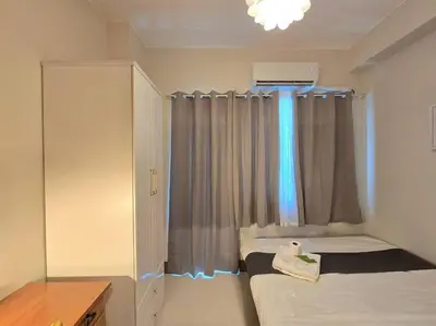 a small room with two beds and a window at 1BR Condotel with Balcony at FAME Residences #FM56 in Manila