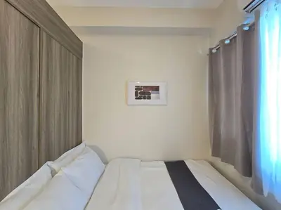 a white bed in a room with a window at 1BR Condotel with Balcony at FAME Residences #FM57 in Manila