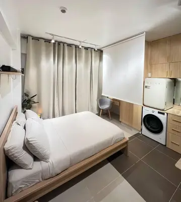 a bedroom with a large bed and a tv at Chic & Cozy Apartment Near BGC with Home Theater Setup in Manila