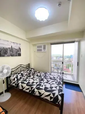 a bedroom with a black and white bed and a window at Easy Escape 1bedroom unit Satori Pasig in Manila