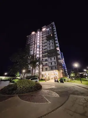 a tall building at night with cars parked in front of it at Easy Escape 1bedroom unit Satori Pasig in Manila
