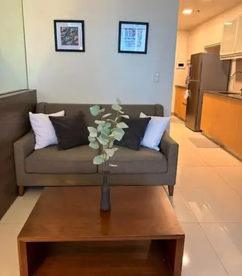 a living room with a couch and a table at Comfy 1BR At Uptown BGC in Manila