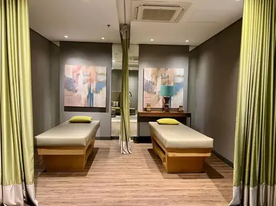 two beds in a room with green curtains at Comfy 1BR At Uptown BGC in Manila