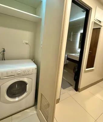 a laundry room with a washing machine and a sink at Comfy 1BR At Uptown BGC in Manila