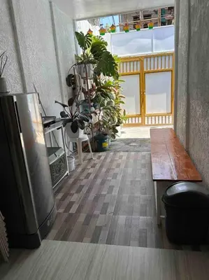 a room with a table and a bench and plants at A private house with swimming pool- Unit1 in Kawit