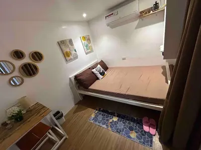 a small room with a small bed with pink shoes on the floor at A private house with swimming pool- Unit1 in Kawit