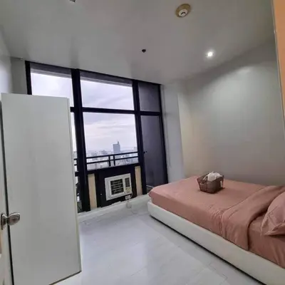a bedroom with a bed and a large window at Cozy Two Bedroom Flat in The Gramercy Residences in Manila