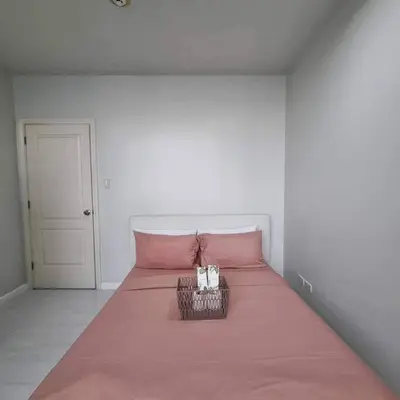 a bedroom with a pink bed with a pink blanket at Cozy Two Bedroom Flat in The Gramercy Residences in Manila