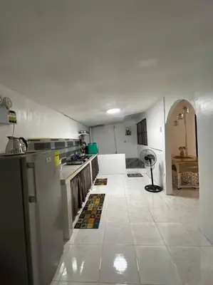 a large white kitchen with a large white tile floor at ACL Staycation Home in Imus & Kawit with portable pool unit 2 in Kawit