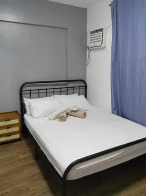 a bed with a pair of shoes sitting on it at Cozy 3 Bedroom Staycation near BGC Makati Airport in Manila