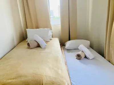 a bed with two pillows on it in a room at Cozy 3 Bedroom Staycation near BGC Makati Airport in Manila